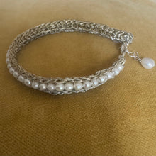 Silver bracelet with pearls on a beige background