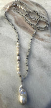 Long beaded necklace with large fresh water pearl pendant.