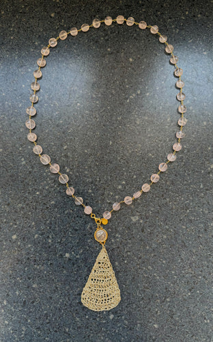 Rose quartz with crochet pendant and coin.