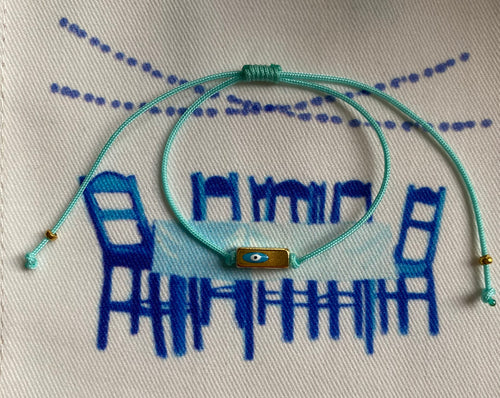 The turquoise string with rectangular prism and enamel eye.