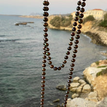 Long black peacock pearl necklace.