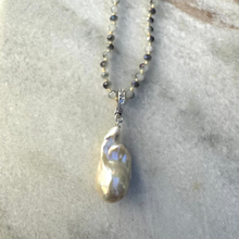 Long beaded necklace with large fresh water pearl pendant.