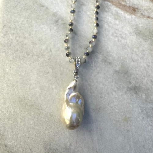 Long beaded necklace with large fresh water pearl pendant.