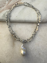 Long beaded necklace with large fresh water pearl pendant.
