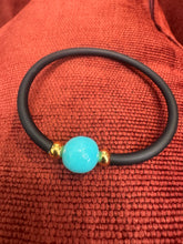 The Mono lustrous fresh water pearl on black silicon.