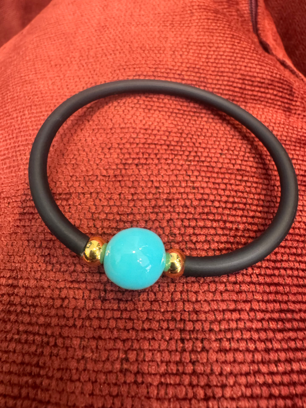 The Mono lustrous fresh water pearl on black silicon.