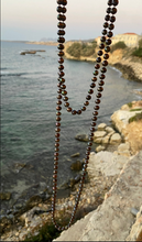 Long black peacock pearl necklace.