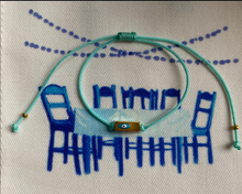 The turquoise string with rectangular prism and enamel eye.