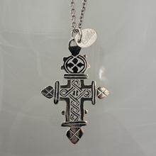 Silver cross pendant necklace on a clear background