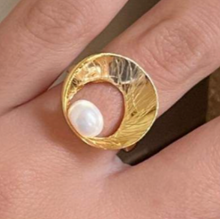Gold ring with a pearl on a finger