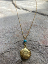 Scallop shell with turquoise bead necklace.