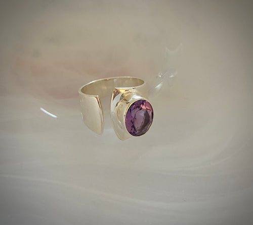 Faceted amethyst stone ring on silver adjustable band.