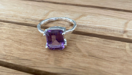 Emerald cut amethyst set with four claw on hammered silver band